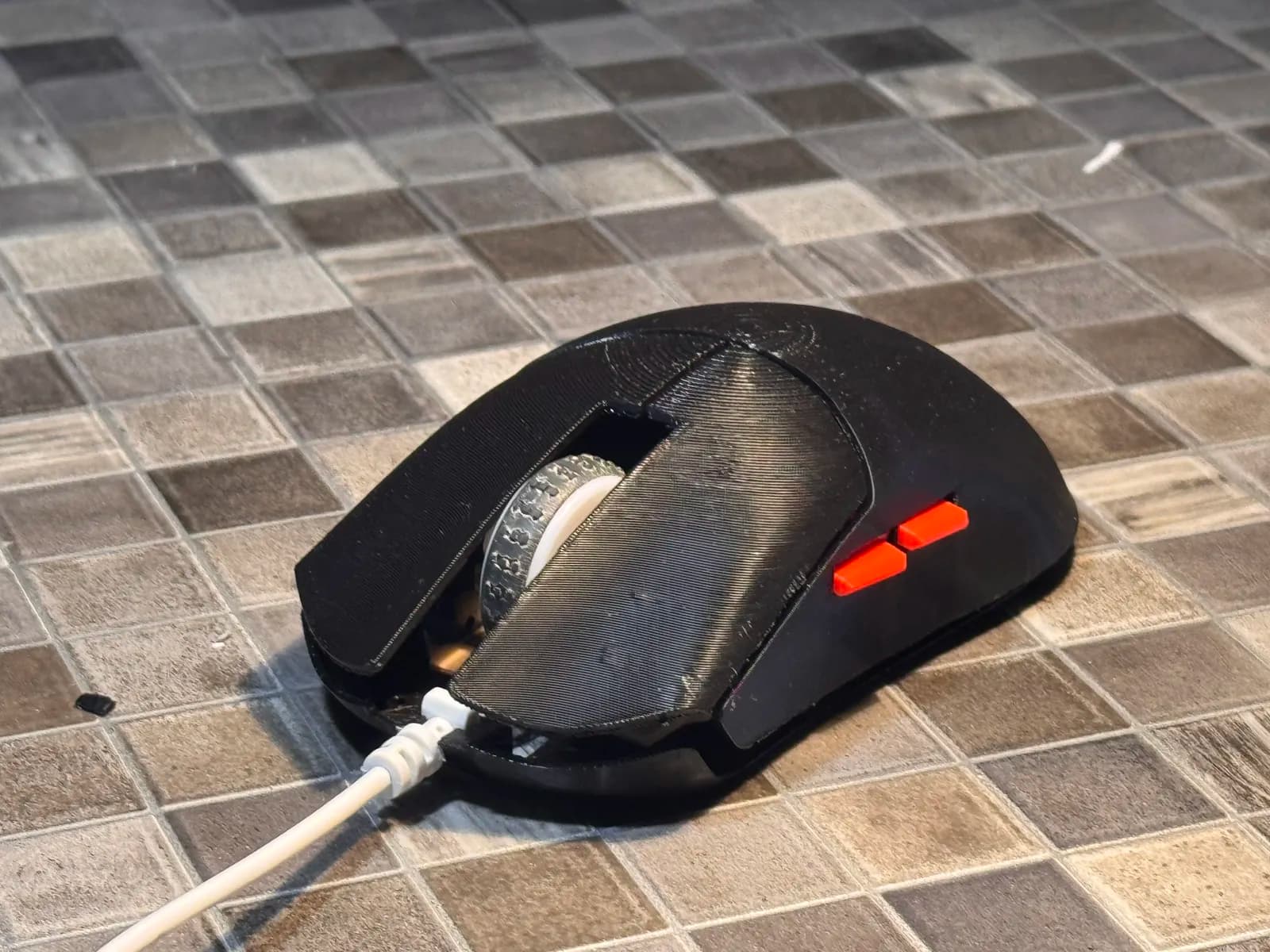 The finished mouse seen from above, black printed shell with two red side buttons